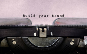 Close-up of typewriter page with "Build your brand" inked into the paper.