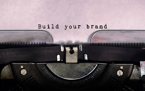 brand-management Close-up of typewriter page with "Build your brand" inked into the paper.