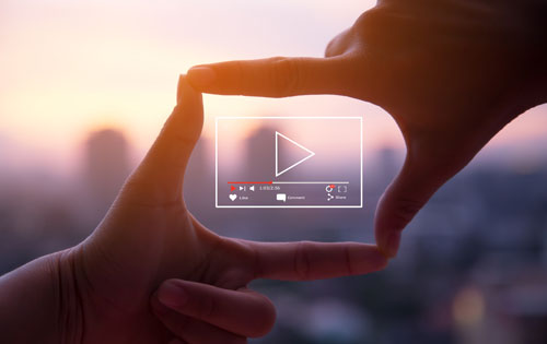 live-action-videos Hands held up together to create a frame with a video player in the center.