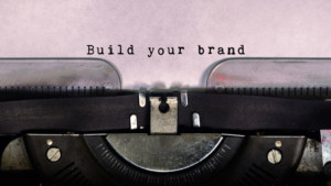 Close-up of typewriter page with "Build your brand" inked into the paper.